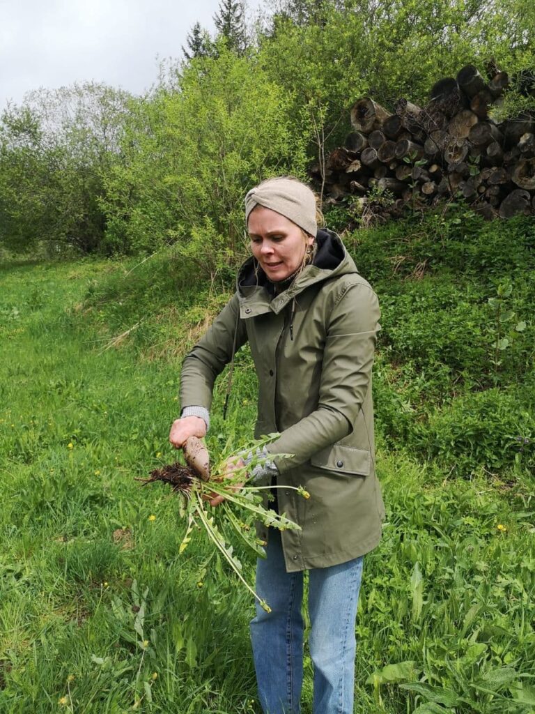 Frau zeigt eine Wurzel und erklärt ihre Verwendung