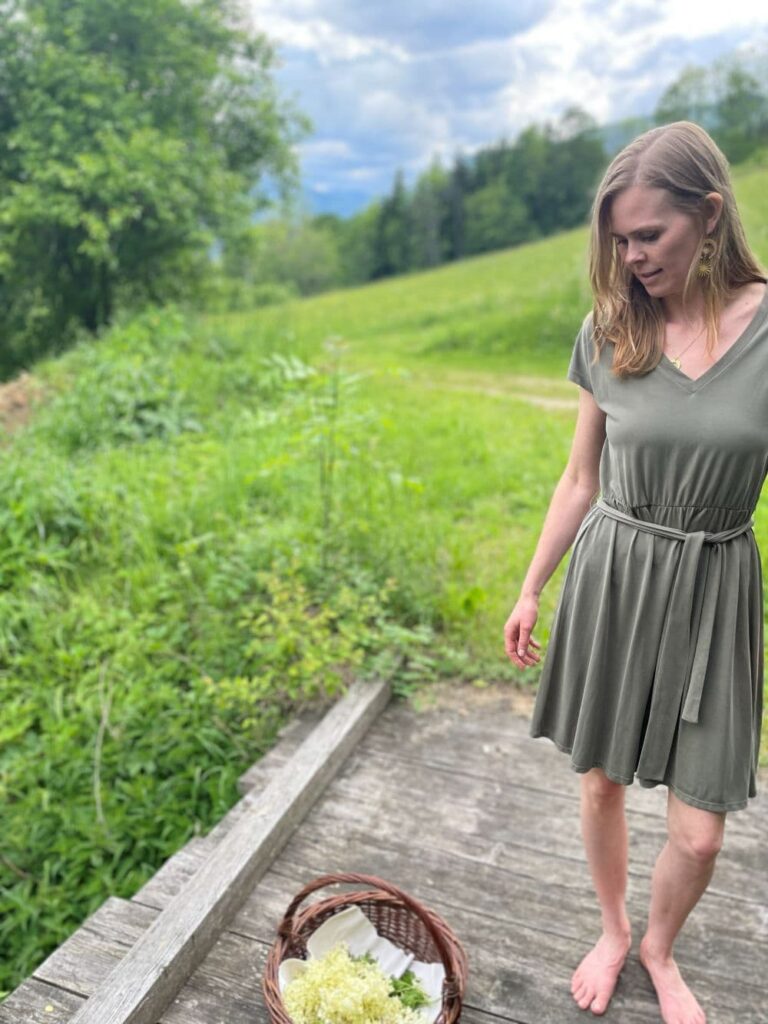 Person sammelt Holunderblüten in einem Korb - bereit für einen Workshop