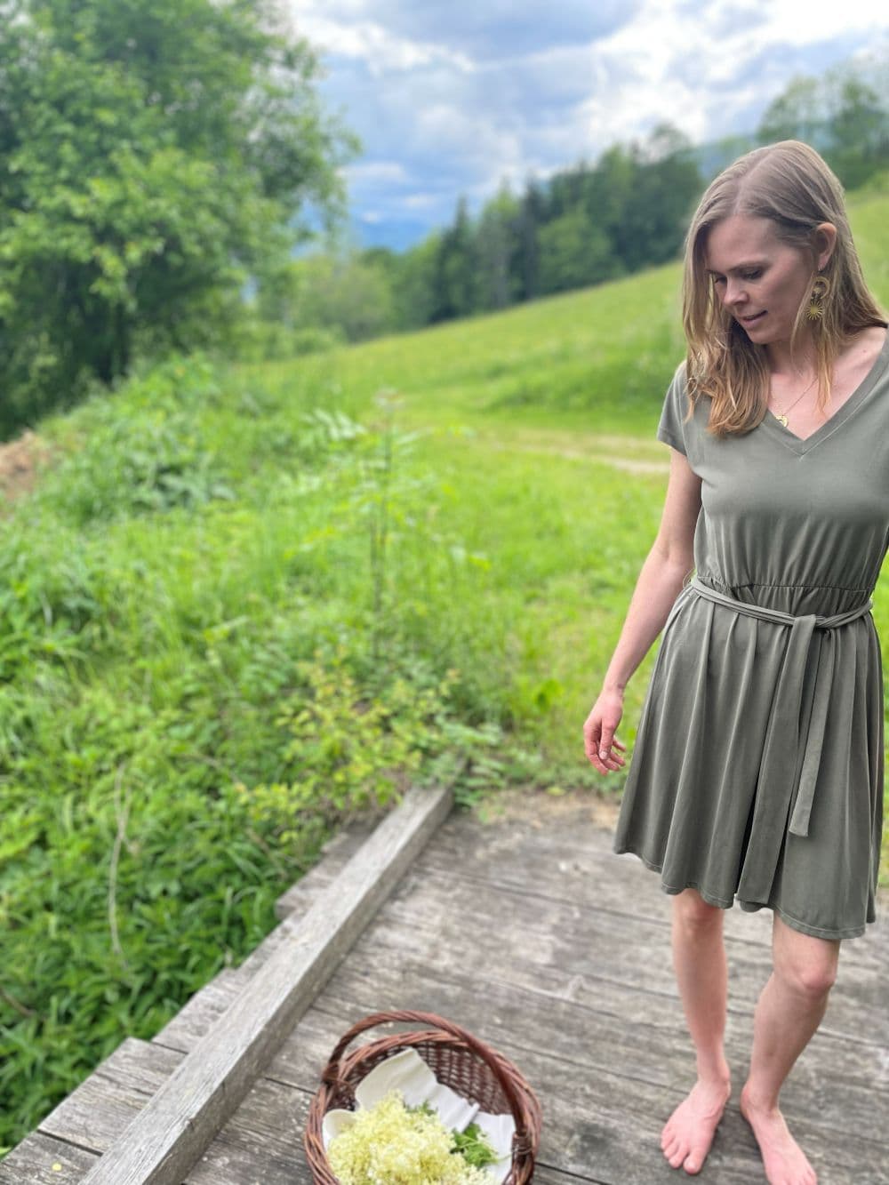 Person sammelt Holunderblüten in einem Korb - bereit für einen Workshop