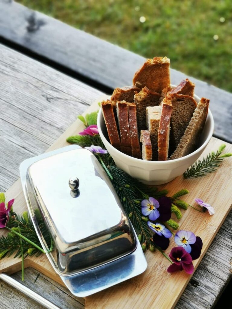 Aufgeschnittenes Brot mit Butter und Blüten - Jause vor dem Workshop
