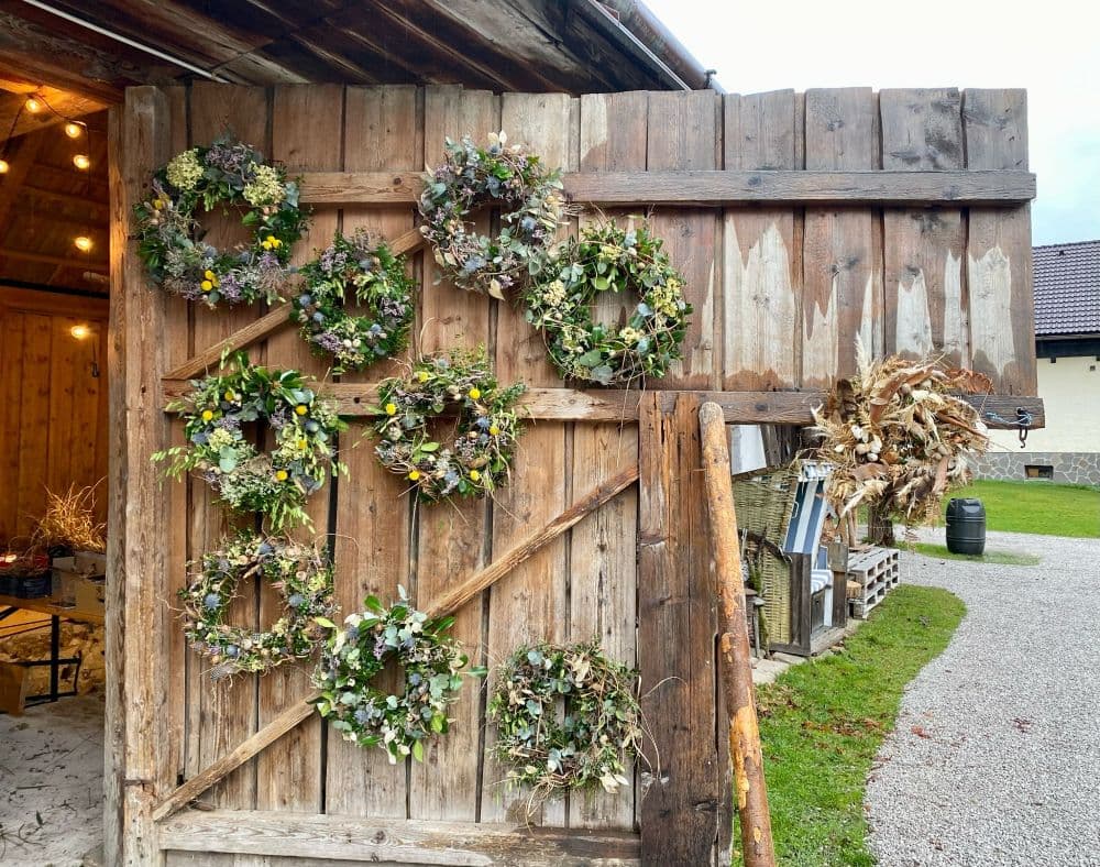 Alte Stalltür mit selbstgemachten Kränzen - Workshopergebnisse dekorativ präsentiert